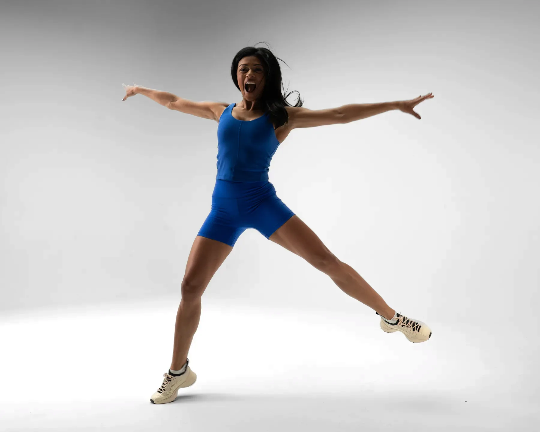 Divya mid-jump with arms extended